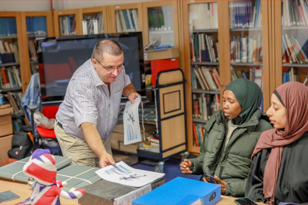 Archivist Paul Dudman showing materials to women at the UEL archive