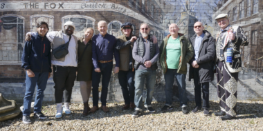 A group of people standing against a wall